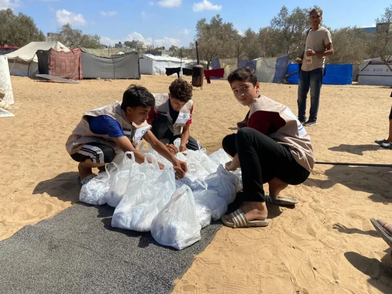 متطوعون يوزعون وجبات ساخنة في مخيم النصيرات بقطاع غزة