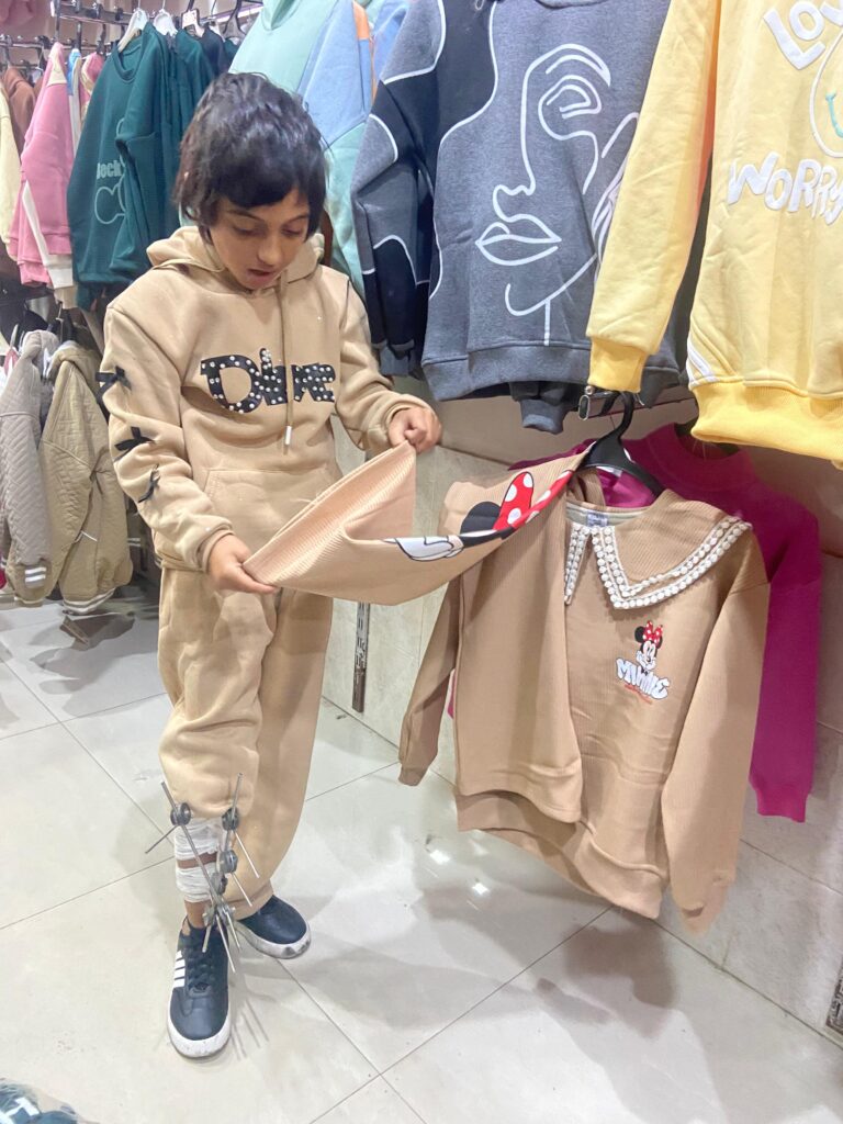 طفلة صغيرة من أطفال غزة الأيتام تحمل معطفًا شتويًا بعد استلامه من جمعية التحالف للإغاثة والتنمية